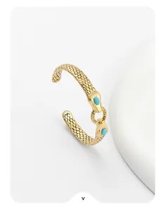 Detailed macro view of gold snake-shaped open cuff with intricate scale textures