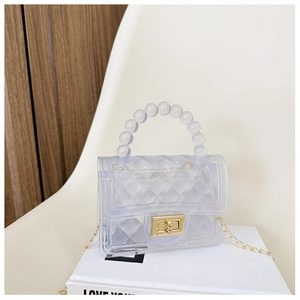 Close-up of PVC jelly bag featuring quilted pattern, beaded handle and golden chain strap
