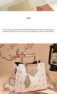 Detail of white textured handbag featuring gold chain handle and leaf pendant decoration