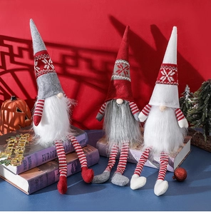 Detail of three Christmas gnomes with striped hats sitting on vintage books decor