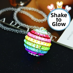 Close-up of a glowing rainbow beaded car ornament with integrated LED sensor lights
