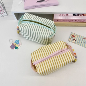 Detail of striped fabric organizers with colorful beaded charms and zip closures