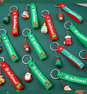 Close-up of PVC silicone Christmas keychains with Santa and Reindeer on green background