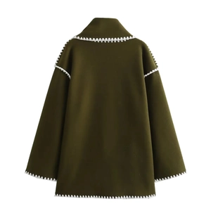 Detail of wool coat in dark army green featuring white wavy contrast stitched edges
