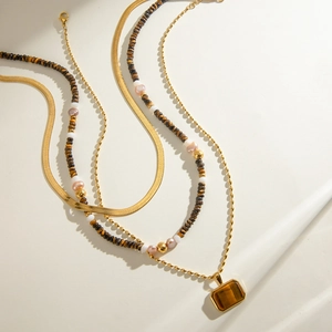 Layered gold necklace with tiger eye stone pendant and colorful beaded pearls strand