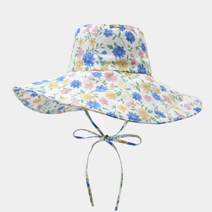 Détail d'un chapeau d'été à fleurs avec large bord et ruban coupe-vent décoratif assorti