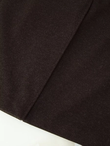 Close-up of thick dark brown wool fabric texture and reinforced seam craftsmanship