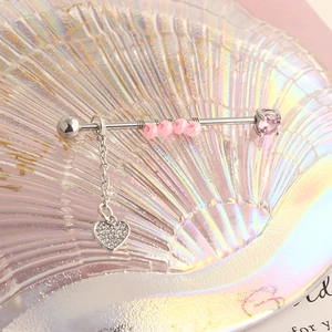 Detail of pink crystal industrial piercing bar with heart-shaped zircon pendant and chain