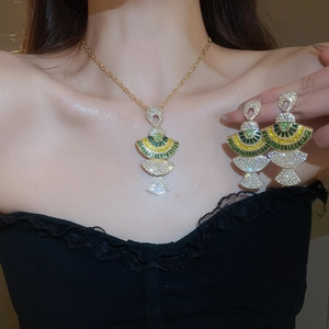 Detail of fan-shaped jewelry set with green and yellow crystals on model neck