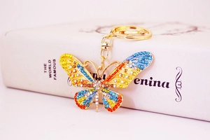 Close-up of golden butterfly keychain with colorful rhinestones and enamel details