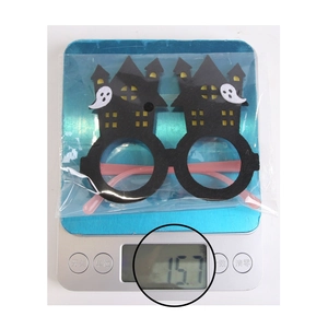 Detailed view of Halloween castle and ghost glasses frame weighing 15.7g on a blue scale