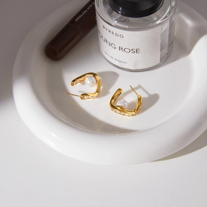Golden U-shaped wave earrings with white pearls and sparkling crystals in an elegant set