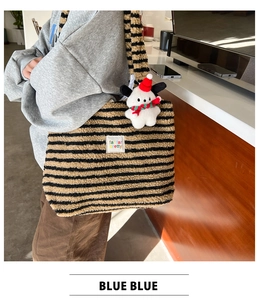 Detail of plush striped tote bag featuring a cute puppy charm and soft fabric texture