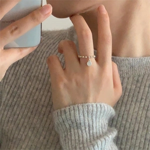 Minimalist 925 sterling silver beaded ring with circular pendant on finger
