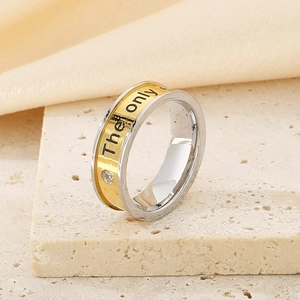Detail of two-tone stainless steel ring with 'The only' engraving and crystal inlay