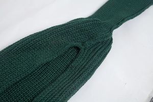 Close-up of deep green knit fabric texture with detailed acrylic yarn weaving pattern