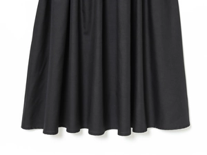 Detailed view of black patchwork dress hem showing high-quality twill fabric texture