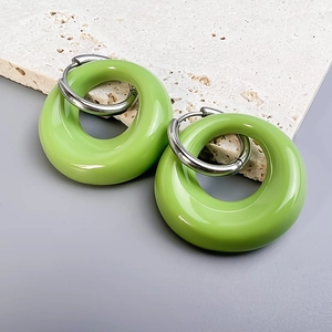 Detail of lime green resin hoop earrings with glossy finish and silver metal clasps