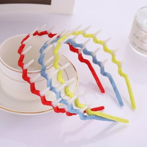 Close-up of wavy plastic headbands in red, blue, and yellow with functional comb teeth