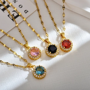 Close-up of four colored crystal pendants with gold finish and zircon halo on white fabric