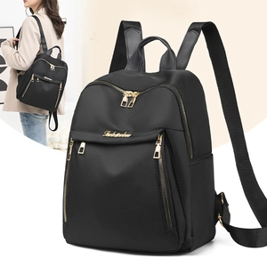 Close-up of black PU leather backpack showing water-resistant texture and gold zipper