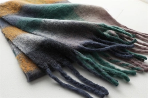 Detailed view of color-block winter scarf showing thick fringe and soft fuzzy texture