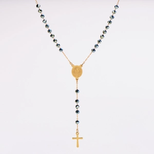 Detail of beaded rosary necklace featuring a gold religious medallion and crucifix