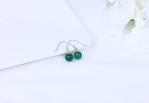 Macro detail of natural green agate beads with S925 sterling silver hooks on white decor