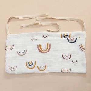 Detail of soft muslin cotton fabric with rainbow print and hanging straps for crib storage