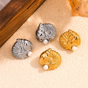 Macro detail of 18K gold and silver plated starfish shell earrings with pearls