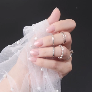 Detail view of five-piece silver ring set with chain texture and solitaire crystal