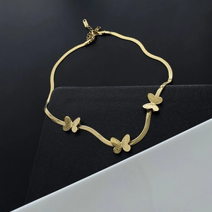 Élégant collier papillon en acier titane doré sur fond géométrique contrasté moderne
