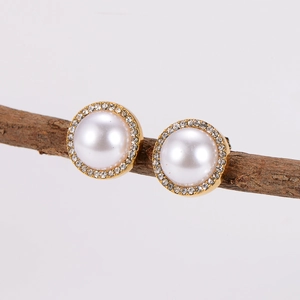 Classic gold pearl stud earrings with sparkling halo crystals on a natural branch