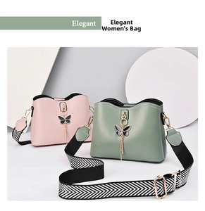 Detail of pink and green PU leather handbags with butterfly charm and woven straps