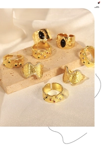 Dettaglio ravvicinato di anelli dorati vintage con zirconi e motivi geometrici