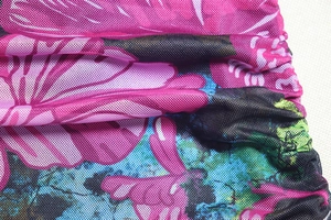 Detail shot of sheer floral mesh fabric with lightweight honeycomb texture in pink and blue