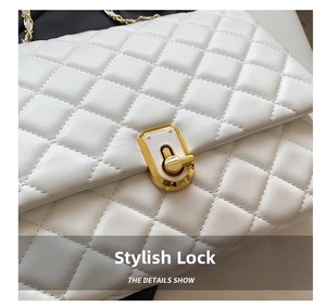 Close-up of golden irregular clasp and quilted leather texture on white crossbody bag