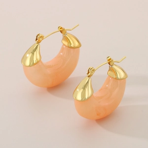 Detail of peach marble resin pendant on golden U-shaped titanium steel earring