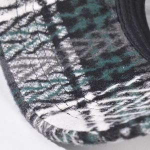 Detailed macro view of the checkered wool baseball cap brim with four reinforced seams