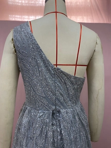 Detail eines silbernen One-Shoulder-Paillettenkleids mit verdecktem Reißverschluss hinten