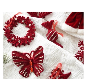 Set of red velvet Christmas ornaments with gold glitter and ribbons on white knit