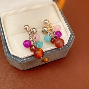 Detail of colorful beaded cluster earrings in a premium velvet gift box display