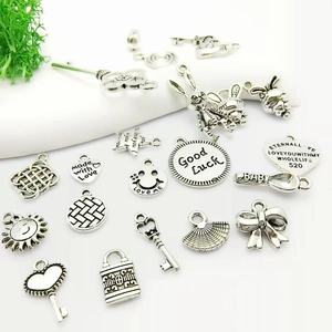 Assortiment de breloques en argent tibétain pour bijoux DIY avec cœurs et clés sur blanc