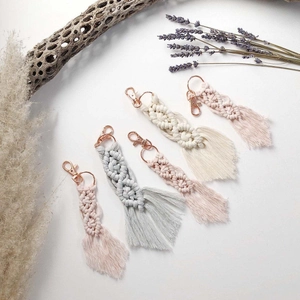 Set of five handmade macrame tassel keychains with rose gold metal rings on white background