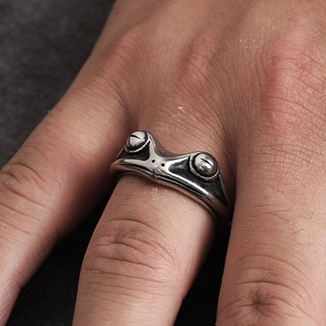 Macro detail of retro silver frog ring showing intricate eye and skin textures