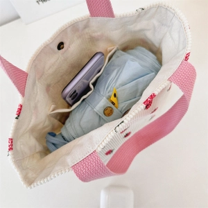 Détails des poches intérieures d'un sac en velours rose avec téléphone et parapluie