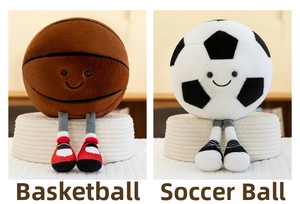 Close-up of basketball and soccer plush toys with dangling legs on a woven tray