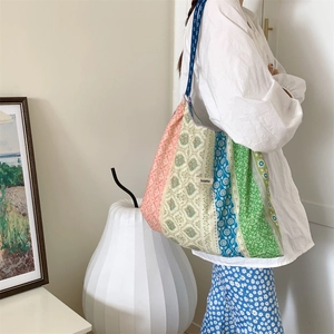 Detail of colorful floral patchwork tote bag with Szakka label and cotton texture