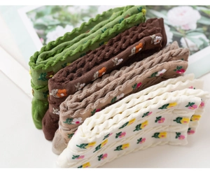 Close-up of five pairs of cotton socks with floral patterns and wavy edges in autumn colors
