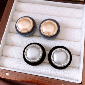 Detail of vintage button style round earrings with velvet borders in a jewelry box